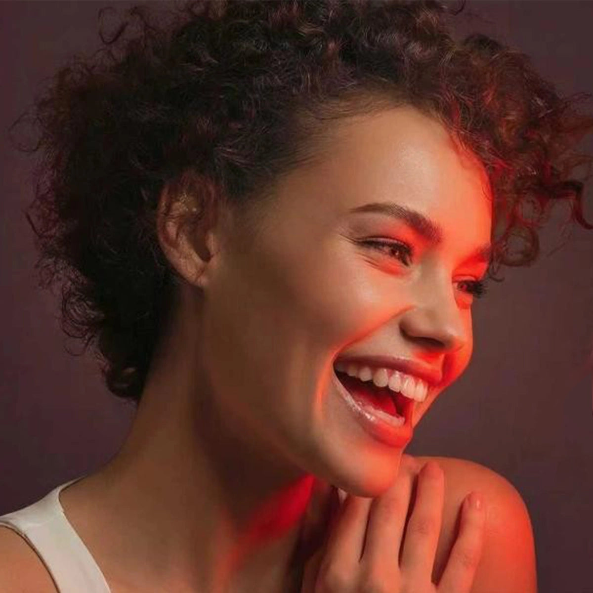 A women Smiling and red light covers half of her face